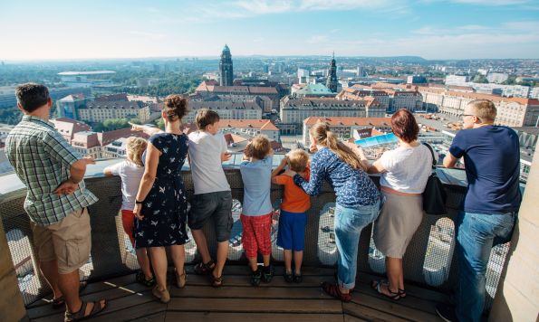 Besucher:innen stehen auf der Aussichtsplattform der Kuppel der Frauenkirche und genießen den Blick über Dresden.